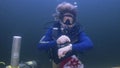 In this photo provided by the Florida Keys News Bureau, diving explorer and medical researcher Dr. Joseph Dituri points to his watch Friday, June 9, 2023, indicating that it is time to surface after spending 100 days in the Jules' Undersea Lodge marine habitat at the bottom of a Key Largo, Fla., lagoon.