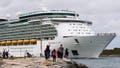 People wave as Royal Caribbeans Mariner of the seas cruise ship departs from Port Canaveral.