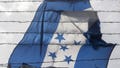 A Honduran flag is seen outside a warehouse used as a hostel for Central American migrants in Piedras Negras, Coahuila state, Mexico on Feb. 7, 2019.