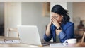 Shot of a young woman looking stressed while using a laptop to work from home