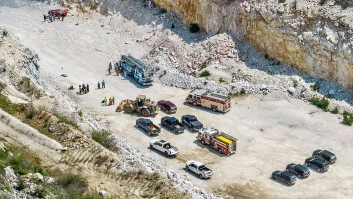 aerial view of car in quarry and emergency vehicles nearby