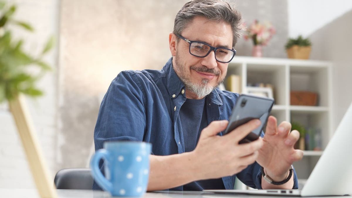 Man smiles at his smartphone