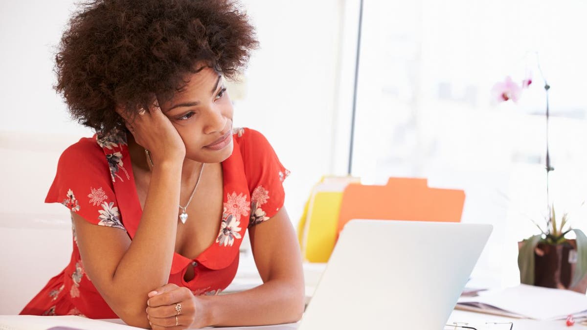 Sad woman stares at her laptop