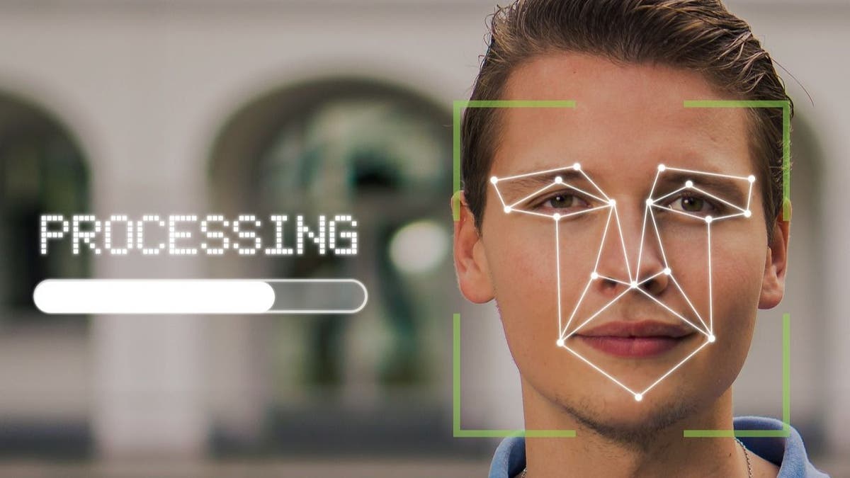 Photo of a person with their face being mapped out by facial recognition software.
