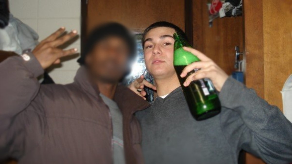 Nilo poses with a afriend while holding a green bottle