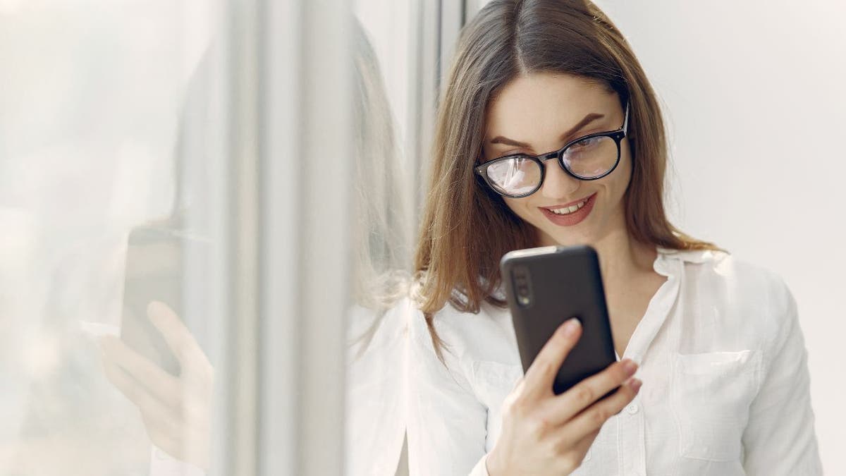 Woman smiles at Android smartphone