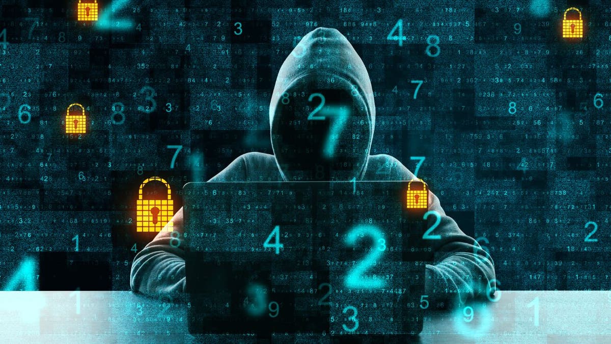 Hacker wearing a hoodie on laptop with numbers and locks popping up