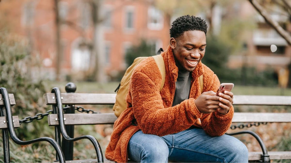 Man smiles at his smartphone