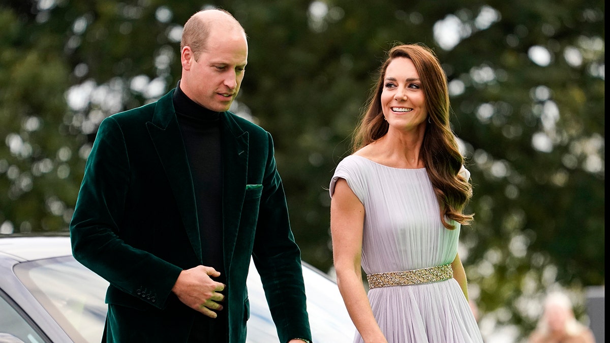 Kate Middleton wearing a lavendar gown walking alongside prince william in a dark green suit