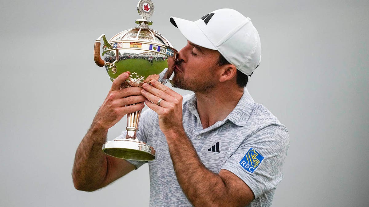 Nick Taylor kisses the trophy