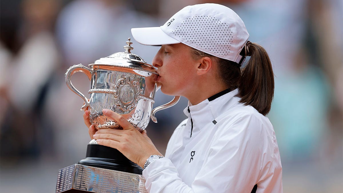 Poland's Iga Swiatek kisses the trophy