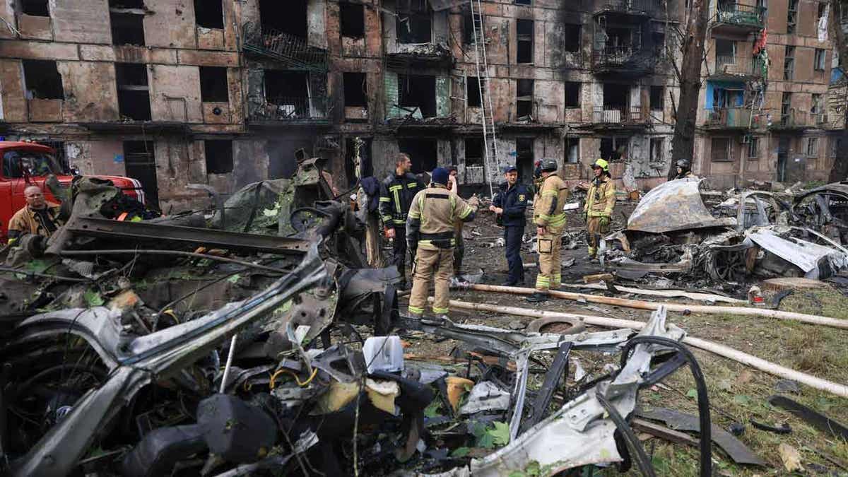 Emergency workers inspect a damaged apartment 