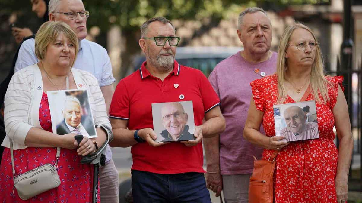 People hold pictures of loved ones