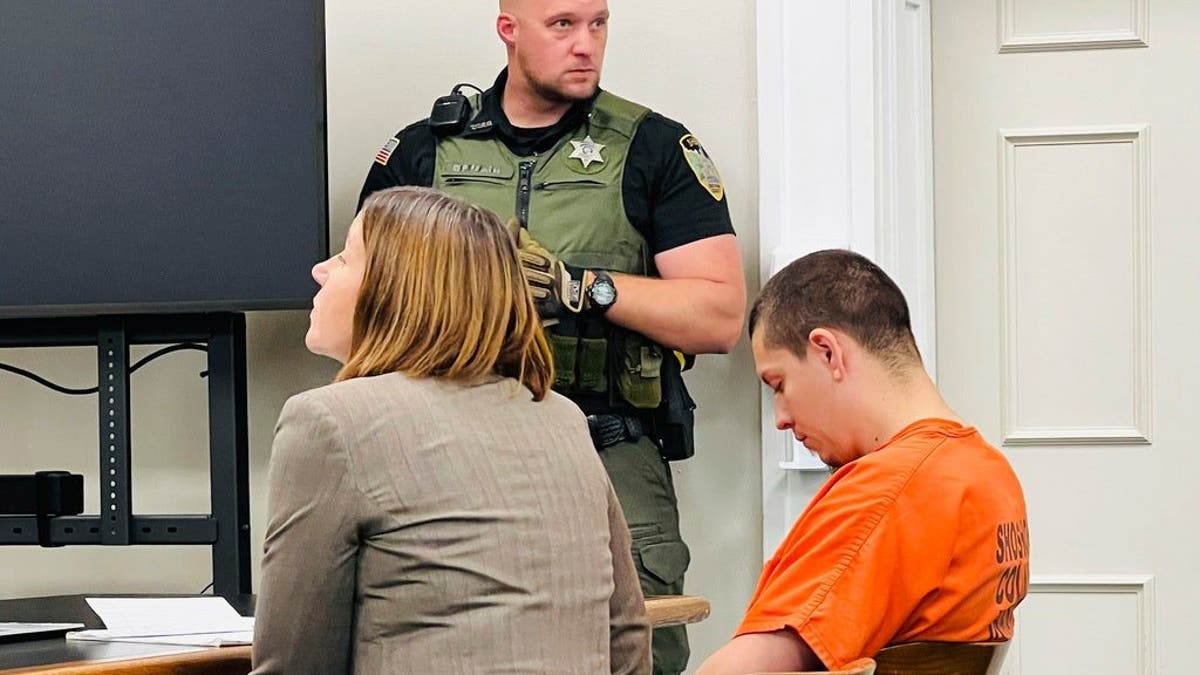 Idaho murder suspect Majorjon Kaylor wearing orange inmate jumpsuit and looking down in court