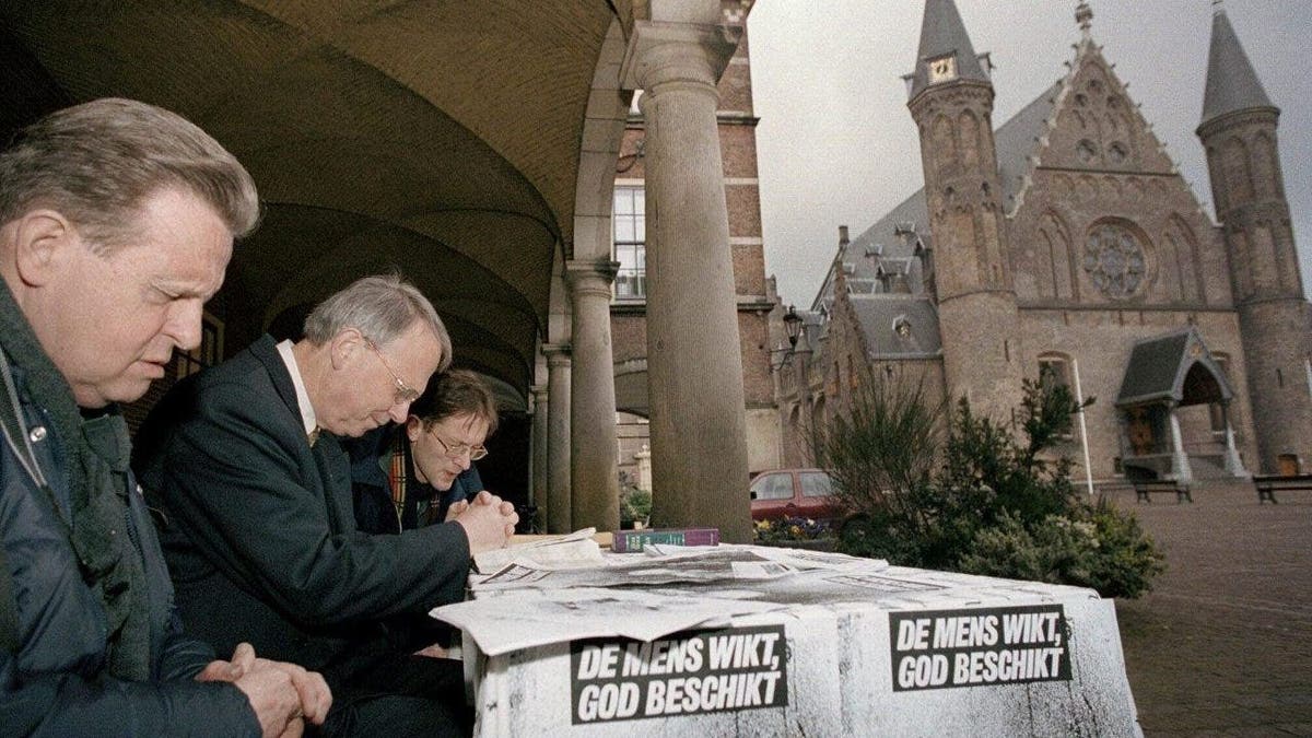 Protesters pray outside Dutch government buildings in The Hague, Netherlands, on as the Upper House of Parliament began debating registration that will legalize euthanasia under strict guidelines. Slogan on table reads, "Human considers, God decides." Several people with autism and intellectual disabilities have been legally euthanized in the Netherlands in recent years because they said they could not lead normal lives, researchers have found. 