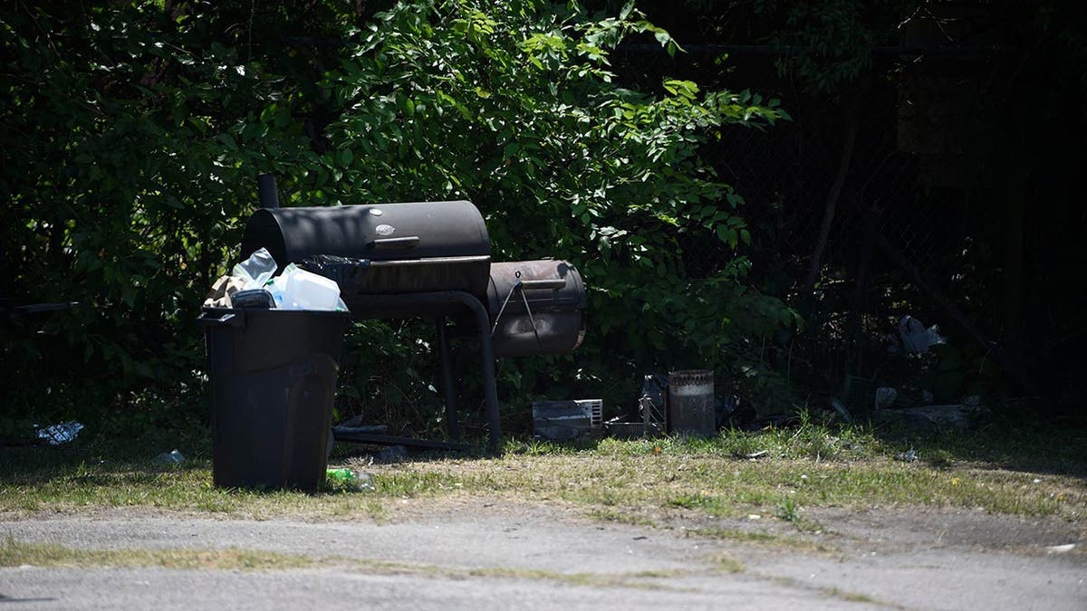 Trash and BBQ outside the Outcast motorcycle gang clubhouse