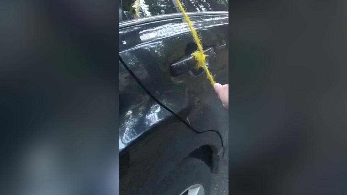 A yellow rope is tied to the car door handle