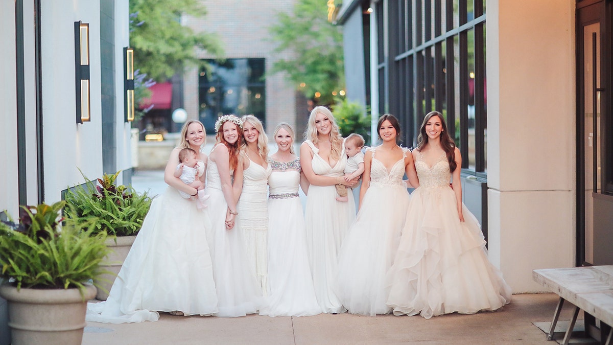 Seven women wearing white dresses.