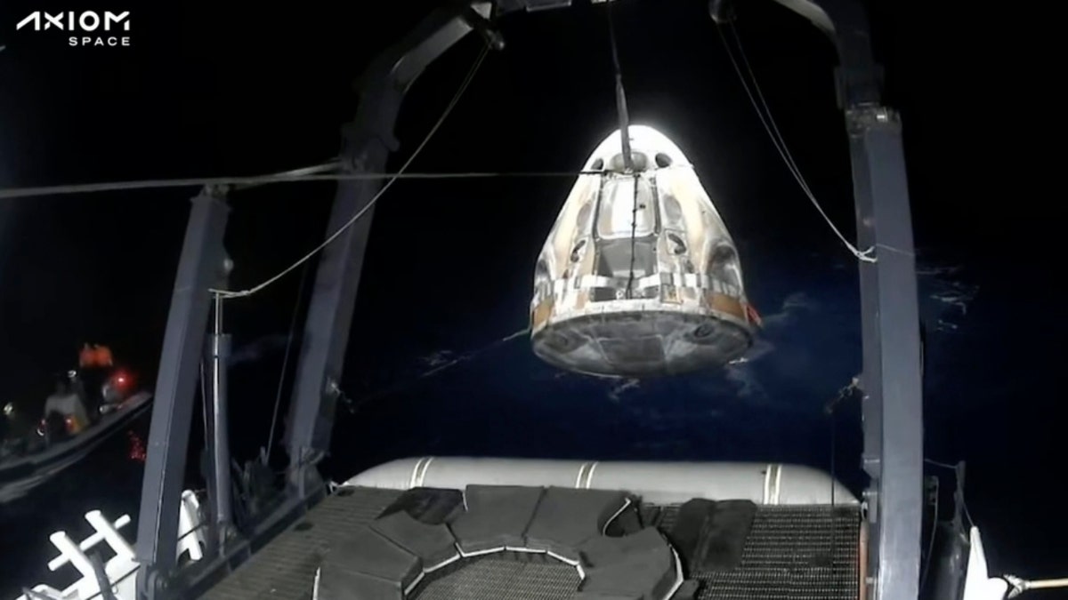 Recovery crews lift and secure the SpaceX Dragon capsule
