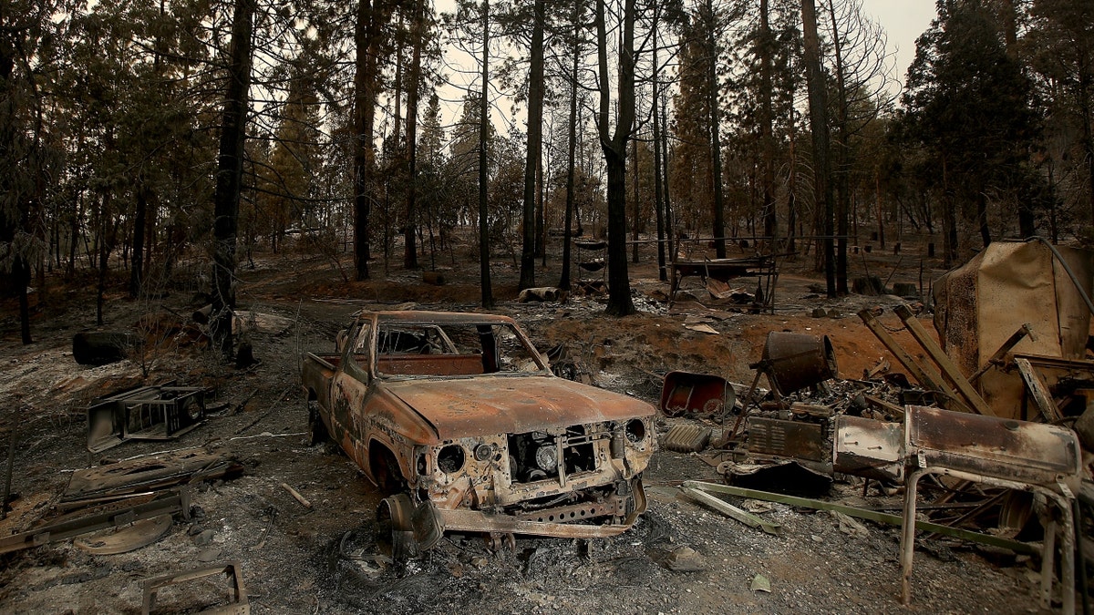 Burned vehicles and remnants of a home from Oak fire