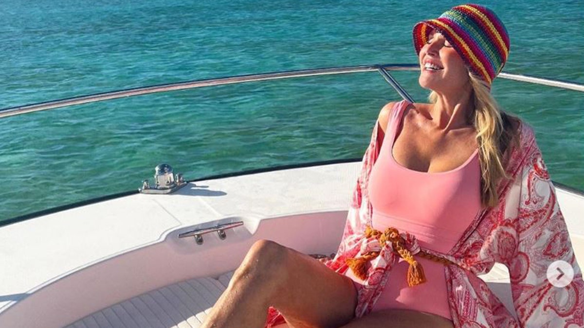 Christie Brinkley wearing a pink bathing suit on a boat
