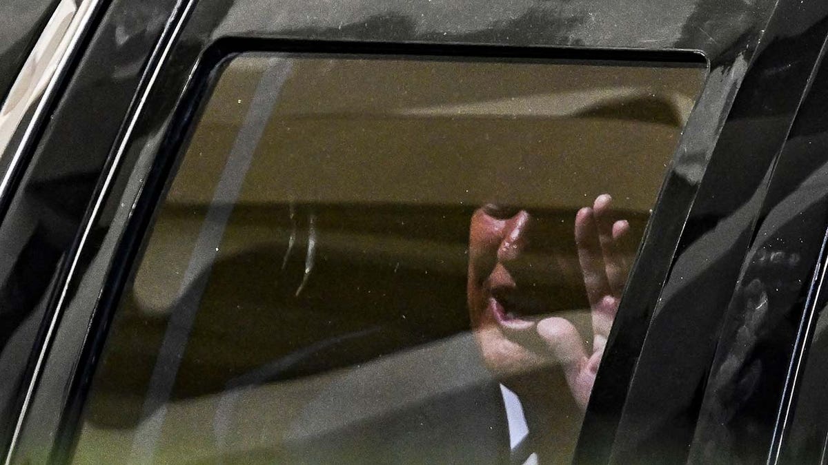 Former US President Donald Trump waves from his vehicle following his appearance at Wilkie D. Ferguson Jr. United States Federal Courthouse