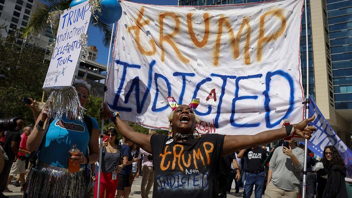 A protestor holds a "Trump Indicted" sign outside the Wilkie D. Ferguson Jr. United States Courthouse