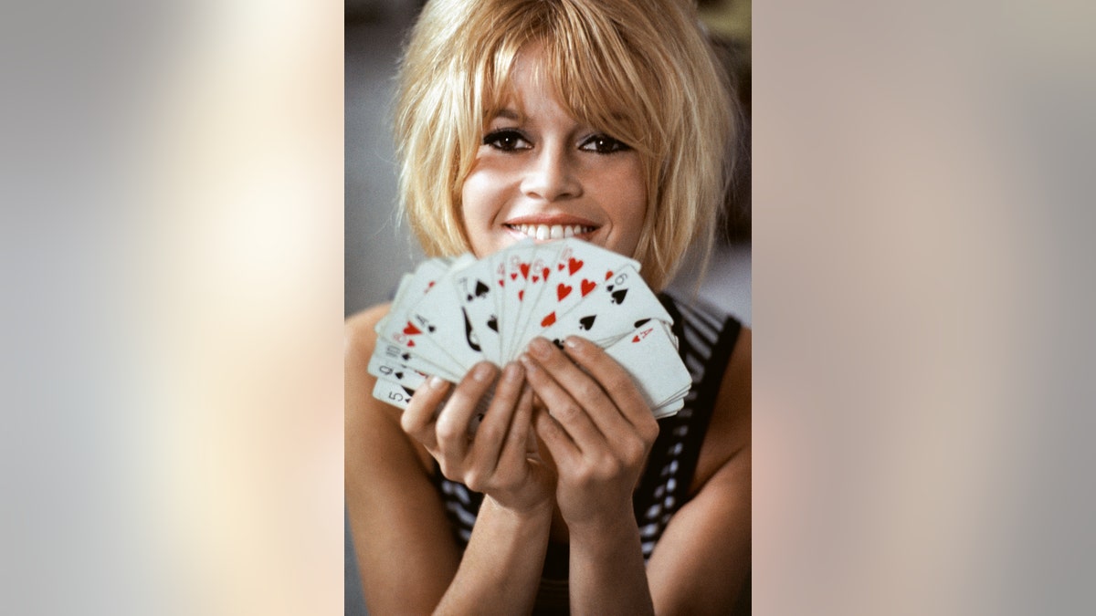 Brigitte Bardot holding a deck of cards