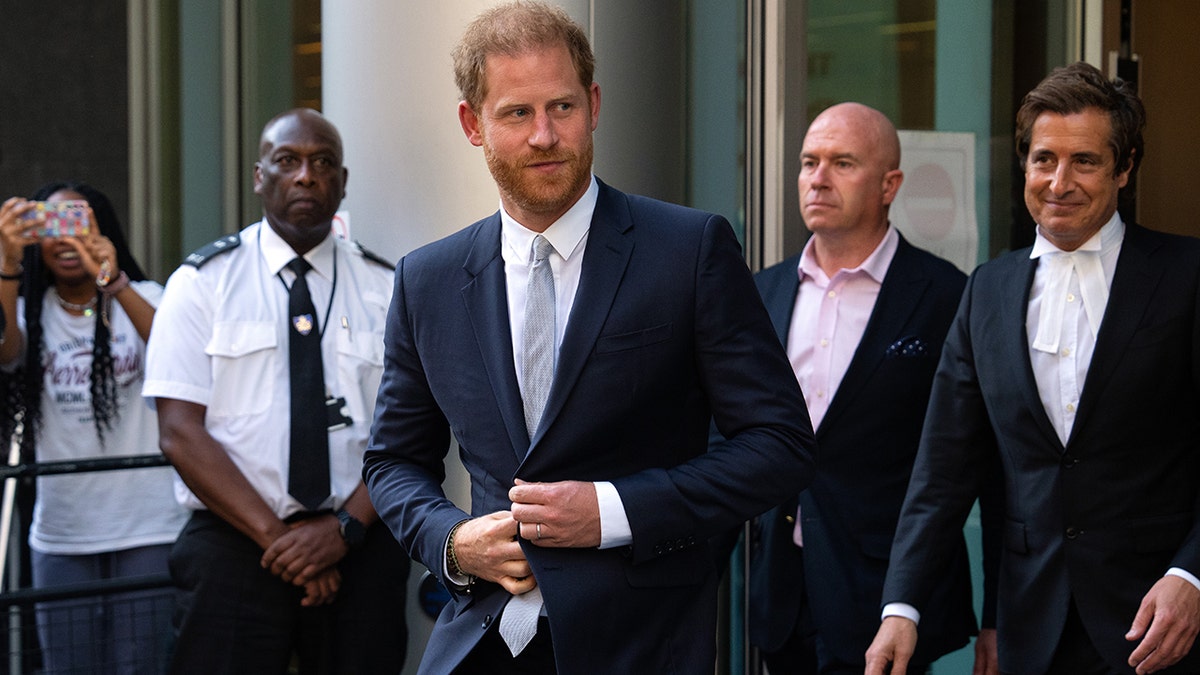Prince Harry wearing a navy blazer with a light blue tie