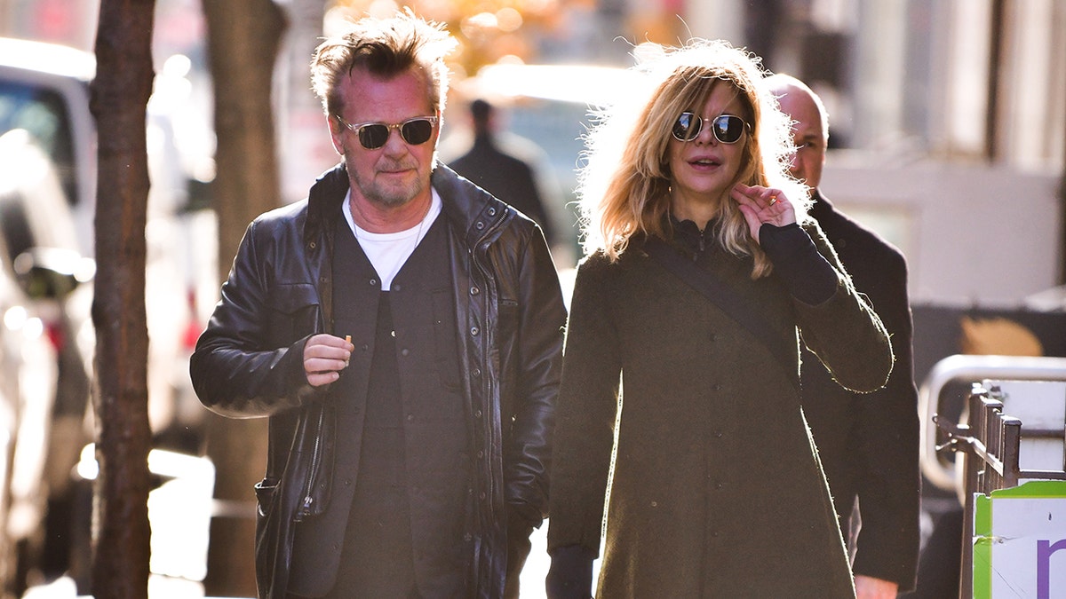 John Mellencamp and Meg Ryan hold hands wearing sunglasses while in New York City in 2018