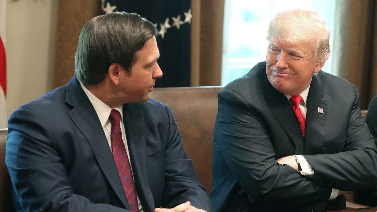 Florida Governor-elect Ron DeSantis (R) sits next to U.S. President Donald Trump