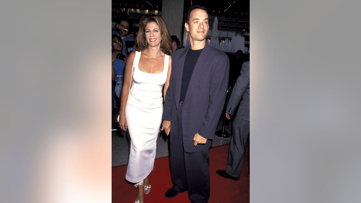 Rita Wilson in a white dress with Tom Hanks in a gray suit