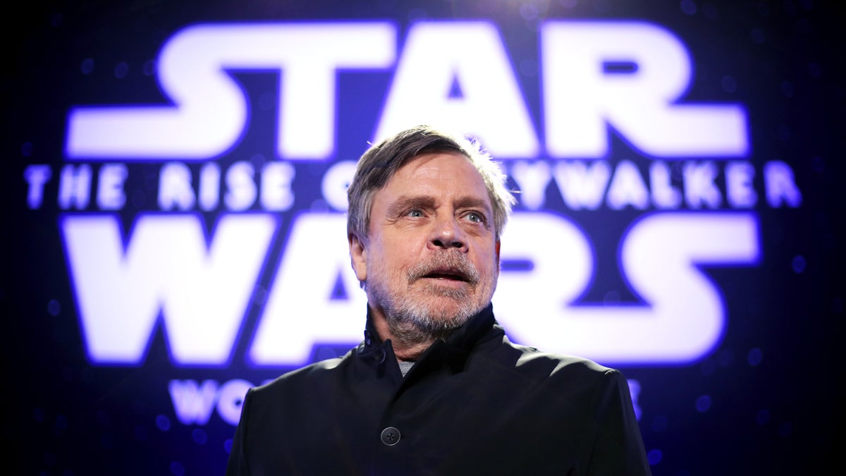 Mark Hamill in front of a Star Wars sign