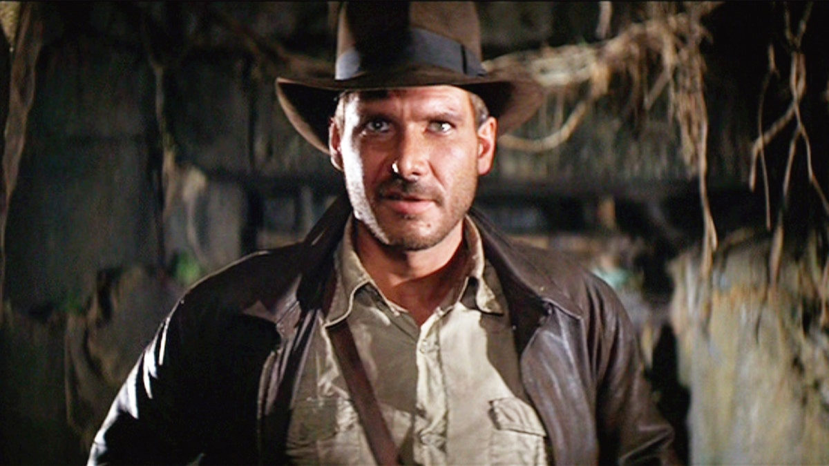 Harrison Ford in a brown leather jacket and brown cowboy hat as Indiana Jones