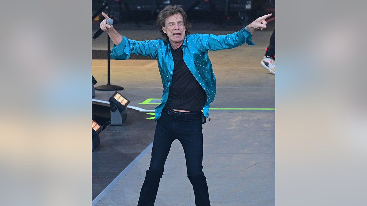 Mick Jagger in Berlin performing with the Rolling Stones pointing in opposite directions on stage