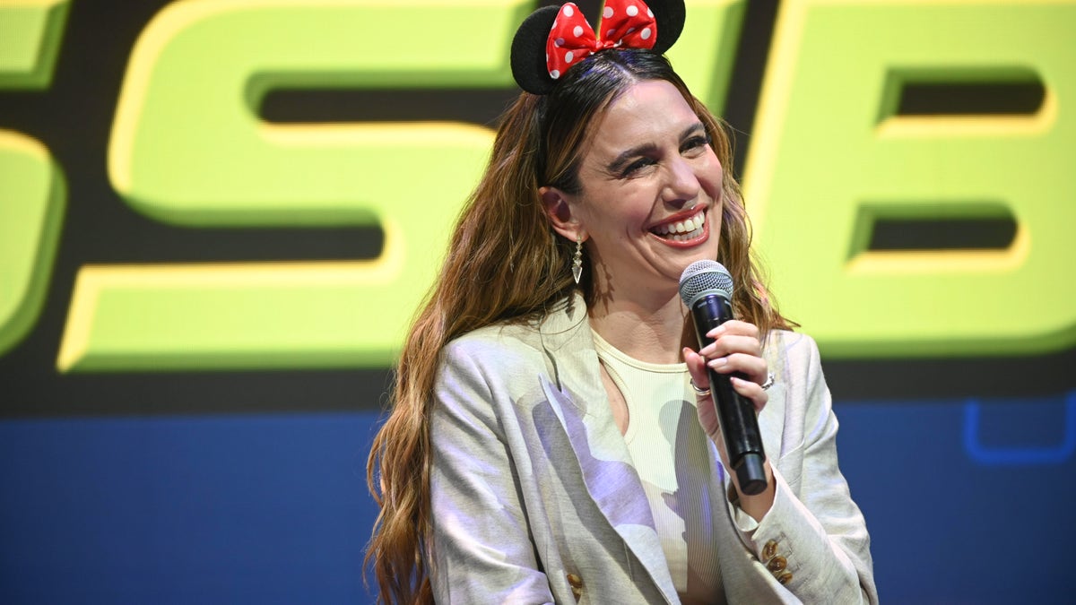 Christy Carlson Romano wearing Minnie ears holding a microphone