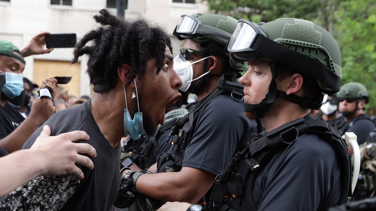 A man menaces a law enforcement officer during a George Floyd-related protest in June 2020 in DC.