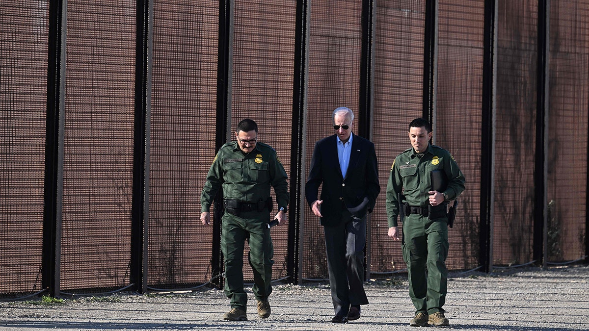 President Biden walking with borderline  officials