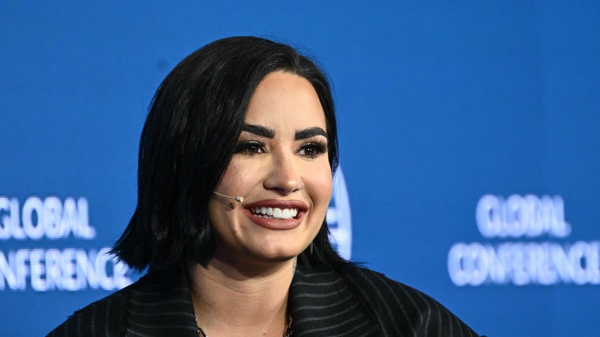 Close up of Demi Lovato smiling with a head mic