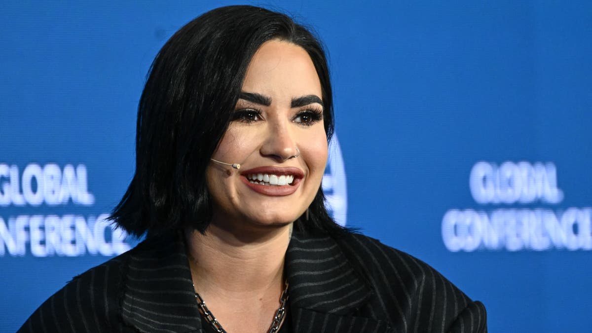 Close up of Demi Lovato smiling with a head mic