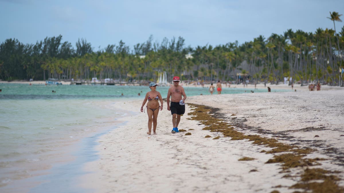 Tourists walk on beach