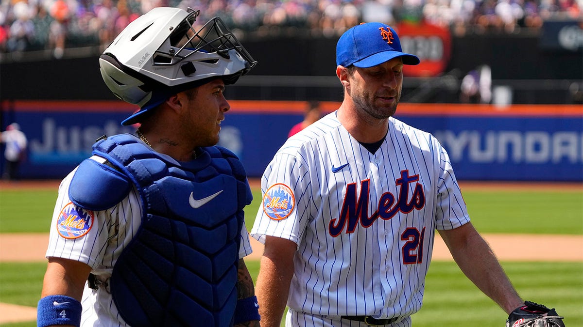 New York Mets' Francisco Alvarez and Max Scherzer walk off the field