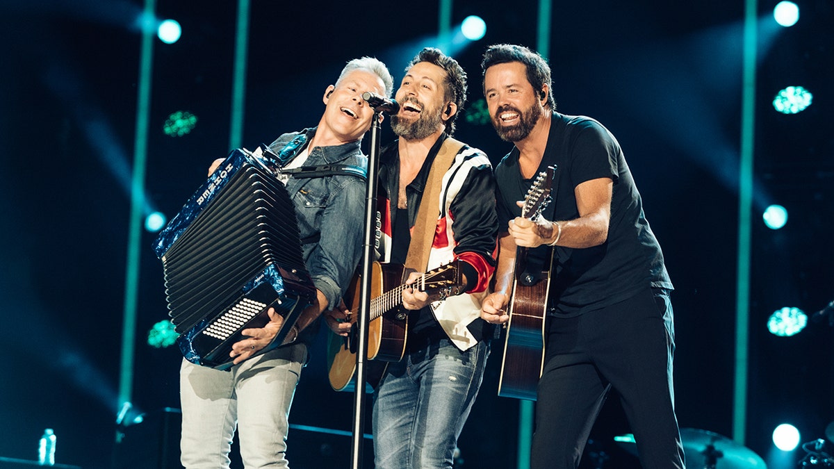 Old Dominion plays on stage at CMA Fest and all three (Trevor Rosen, Matthew, Ramsey and Brad Tursi) lean into the microphone