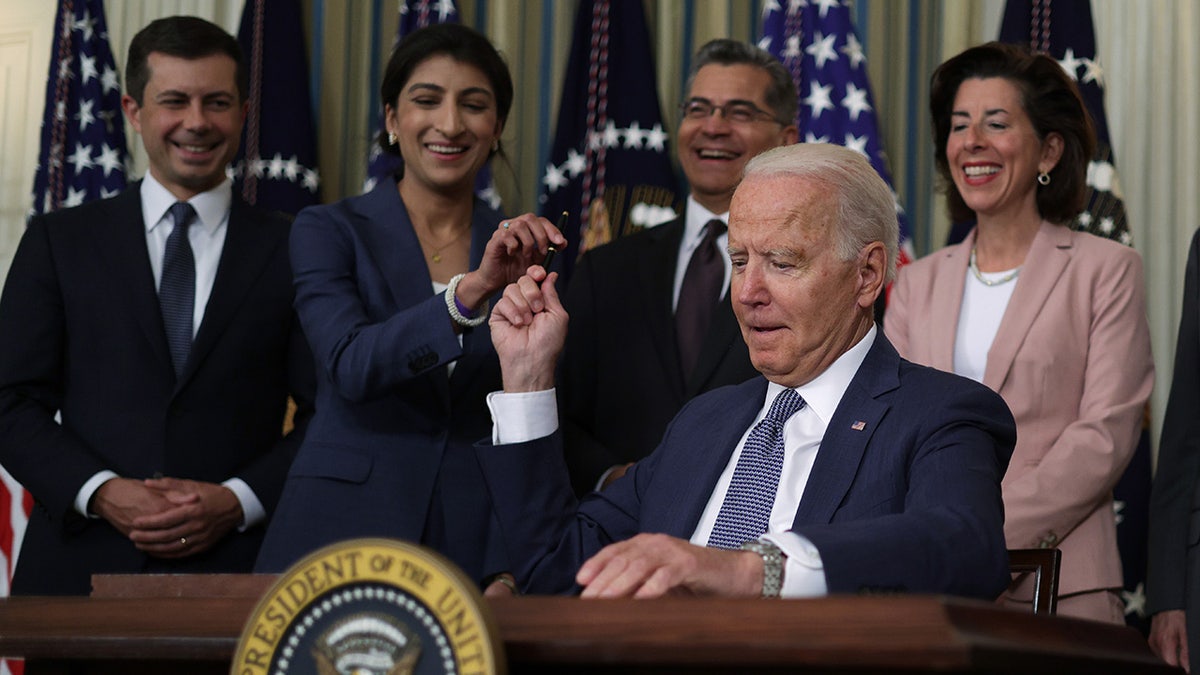 FTC chair hands Biden a pen