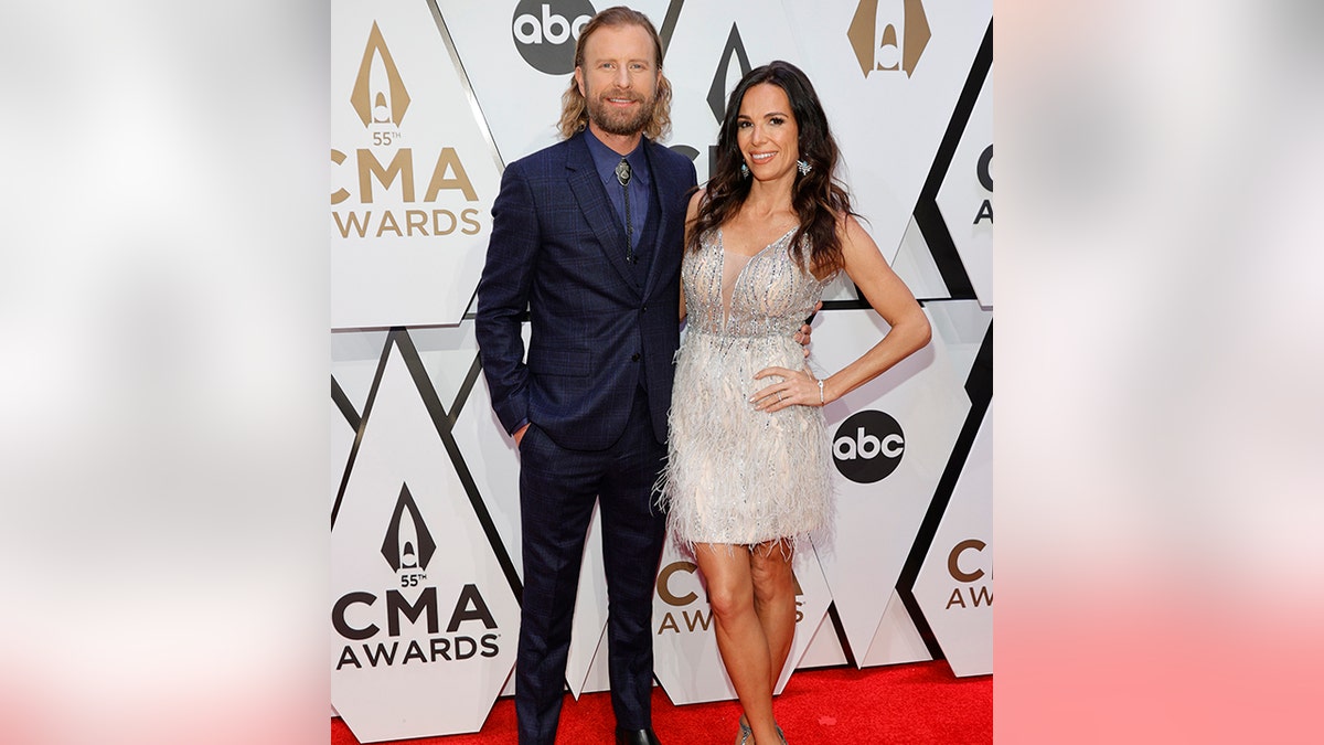 Dierks Bentley poses at the CMA Awards with his wife Cassidy in a white dress