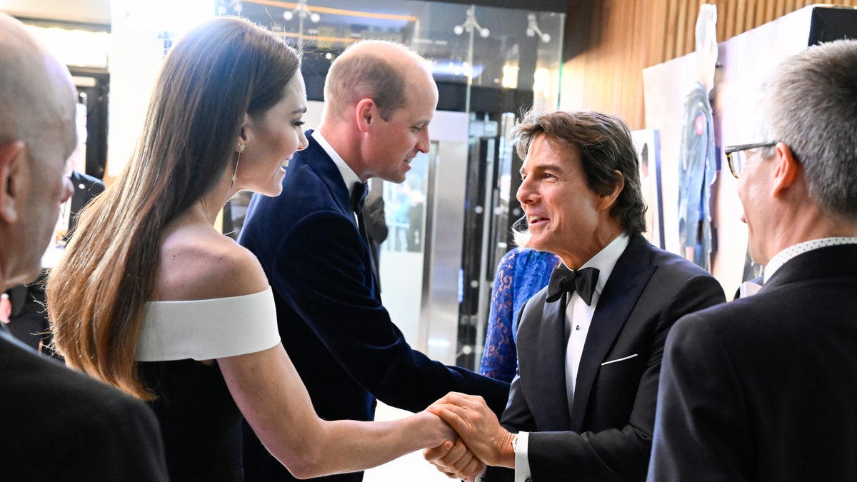Tom Cruise holds Kate Middleton's hand with Prince William shaking hands in the background.