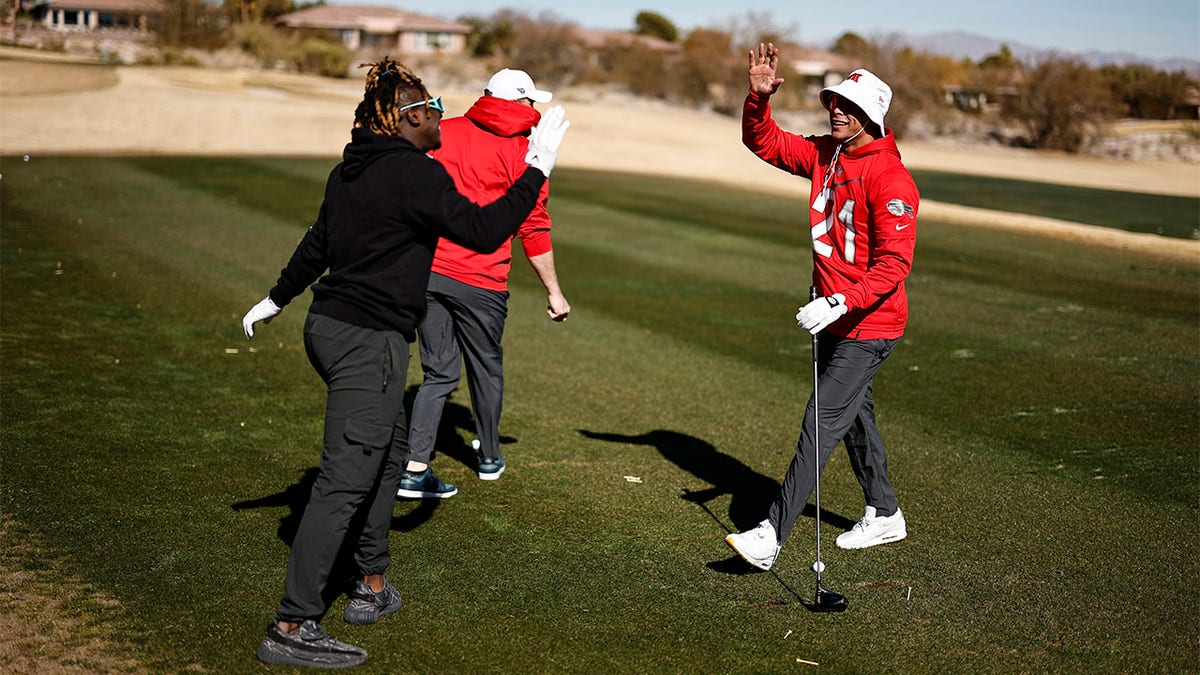 Jordan Poyer gives a high-five at a golf course