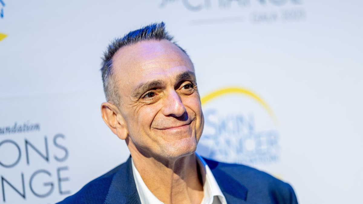 Close up of Hank Azaria smiling in a blue suit