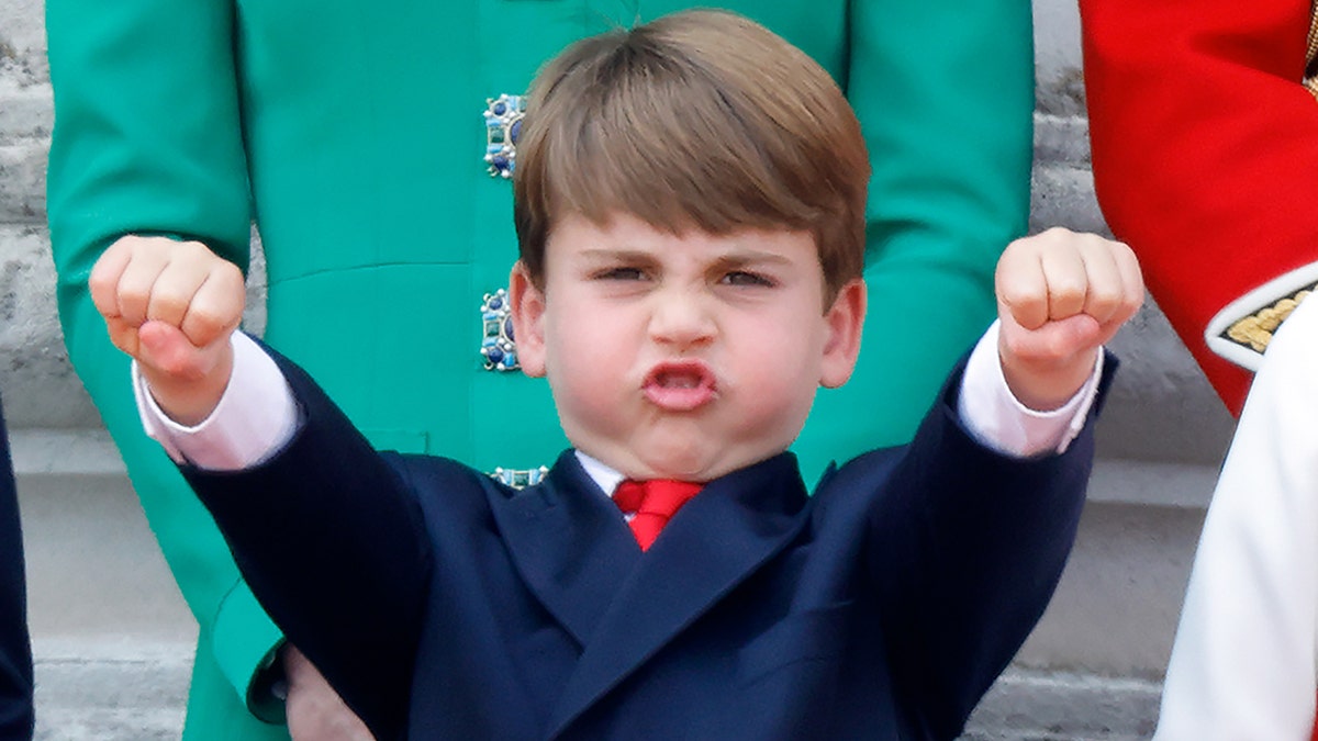 Prince Louis sticks his arms out in the air defiantly on the royal balcony after Trooping the Colour ceremony