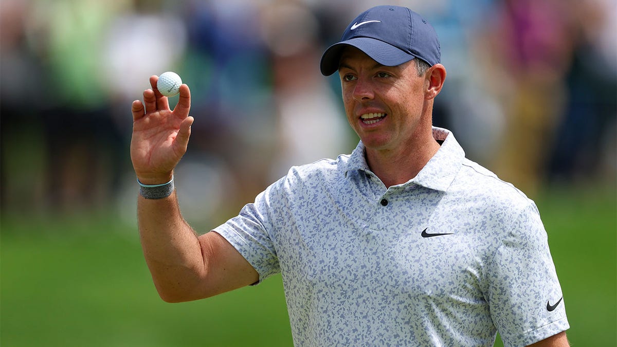 Rory McIlroy waves after making a hole-in-one